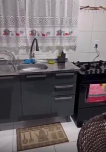 una cocina con fregadero y estufa en Casa temporada Tarumã 02, en Tangará da Serra 6 fotos más