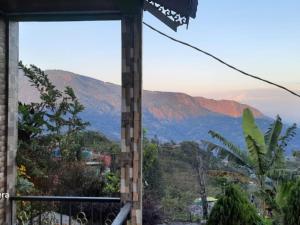 a view of a mountain range from a balcony at Peshok Subba Homestay By StayApart in Darjeeling