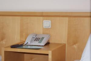 un teléfono sentado sobre una mesa de madera en Hotel Herian, en Parsdorf