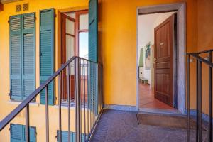 Un pasillo con contraventanas de colores y una puerta. en Casa Motti, en Verbania
