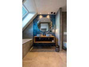 a bathroom with a sink and a mirror at Modern villa in De Cocksdorp near the beach in De Cocksdorp