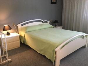 1 dormitorio con 1 cama blanca y 2 mesitas de noche en Albergo Diana, en Legnaro