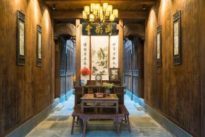 a hallway with a table and a chandelier at Wuyuan Jiwei Mountain Lodge (Sixi-Yan Village Scenic Area) in Wuyuan