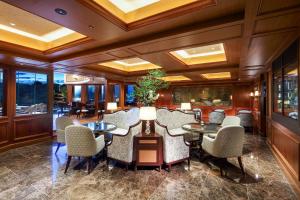 a dining room with tables and chairs and windows at Hotel Chinzanso Tokyo in Tokyo