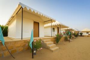 a building with a bunch of umbrellas and flowers at The Saffron Desert Camp, Jaisalmer in Jaisalmer +25 photos