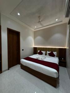 a bedroom with a large bed with red pillows at THE TAJ PEARL HOTEL in Agra