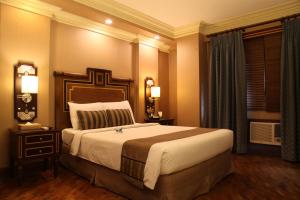 a hotel room with a large bed and a window at Herald Suites Polaris in Manila +26 photos