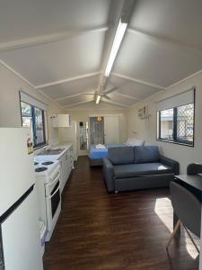 a living room with a blue couch and a kitchen at Kin Kora Village in Gladstone