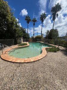 a small swimming pool with a brick path around it at Kin Kora Village in Gladstone