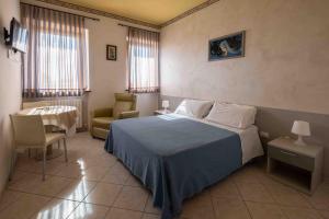 Un dormitorio con una cama, una silla y una mesa. en Il Castagno, en Orciano di Pesaro