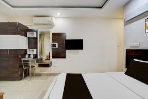 a bedroom with a bed and a tv on the wall at Townhouse Shivamogga Railway Junction Formerly Amma Residency in Shimoga