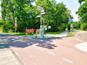 スコールルにあるStunning apartment in Schoorl, North Hollandâ you can bike to the beachのポールに道路標識がある空いている道路