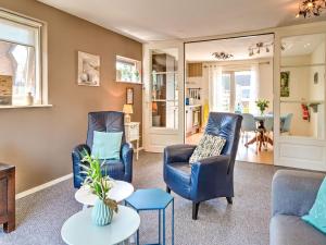 スコールルにあるStunning apartment in Schoorl, North Hollandâ you can bike to the beachのリビングルーム(青い椅子2脚、テーブル付)