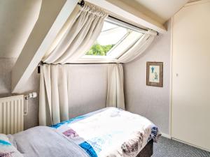 スコールルにあるStunning apartment in Schoorl, North Hollandâ you can bike to the beachのベッドと窓のある寝室
