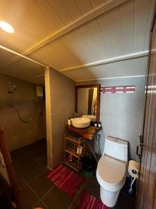 a bathroom with a white toilet and a sink at Beach front cottage in Haad Pleayleam