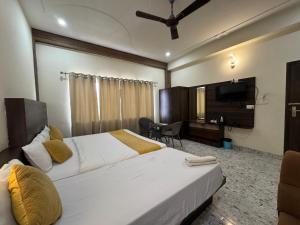 a hotel room with a bed and a television at Hotel Vrinda Sarovar in Mathura