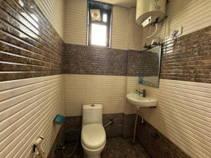 a bathroom with a toilet and a sink at Hotel Vrinda Sarovar in Mathura +12 photos