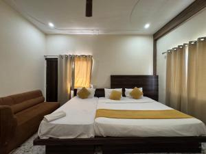 a bedroom with a large bed and a couch at Hotel Vrinda Sarovar in Mathura