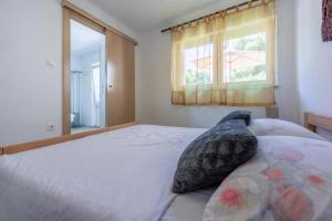 a bedroom with a bed with a pillow on it at Apartment Jurja in Ledenice +16 photos