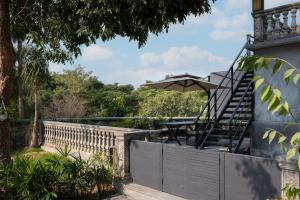 un patio con una mesa y una sombrilla en Sunset Garden Hotel, en Gulang Yu