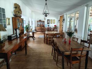 a dining room with wooden tables and chairs at Garden of Eden Cottages and Guest House in Mbabane