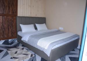 un lit avec des draps blancs et des oreillers dans une chambre dans l'établissement Hotel ShivDham Naimisharanya, à Naimishāranya 4 autres photos