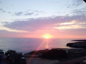 a sunset over the ocean with the sun in the sky at B&B Portorosso in Monopoli