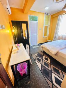 a small room with a bed and a table and a desk at Central Beautiful & peaceful Private bedroom AC, Very fast WiFi 1 in Dar es Salaam