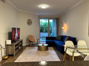 a living room with a blue couch and a table at Spacious 1bdrm apartment 10 mins to Cedars-Sinai by car FREE Parking, King bed in Los Angeles