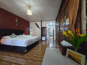 a bedroom with a bed and a vase of flowers at Amban Beach House in Manokwari