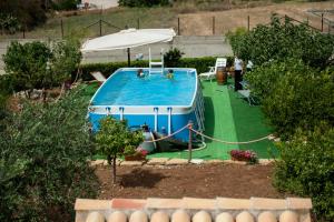 a swimming pool in a yard with an umbrella at Casa Vacanza Dattilo - Casa con Piscina vicino Trapani in Dattilo