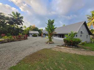a house with a gravel driveway in front of it at MIRZ Accomodation Villa 2 in Pacific Harbour