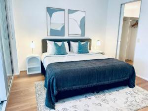Un dormitorio con una cama grande con almohadas azules. en Ocean View Spa Apartment in Q Tower, en Gold Coast
