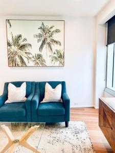 Una sala de estar con un sofá azul con dos almohadas blancas. en Ocean View Spa Apartment in Q Tower, en Gold Coast
