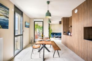 a dining room with a wooden table and chairs at BnGo I Luxury & Prestige I Garage, Terrace, in Lyon