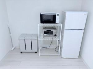 ein Zimmer mit Fernseher auf einem Wagen mit Kühlschrank in der Unterkunft G-stay in Wada