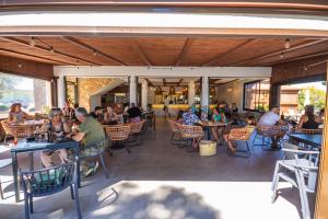 a group of people sitting at tables in a restaurant at Camping Ametlla in L'Ametlla de Mar