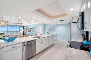 cocina grande con armarios blancos y paredes azules en Poinciana 4A, en Ybel