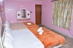 a bedroom with a large bed with towels on it at Mookambigai Residency in Kodaikānāl +6 photos