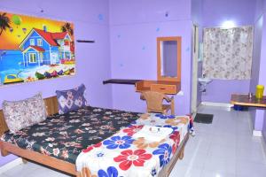 a bedroom with a bed and a painting on the wall at Mookambigai Residency in Kodaikānāl