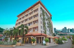 Un gran edificio con árboles delante. en SCN City Hotel Rayong, en Ban Chang