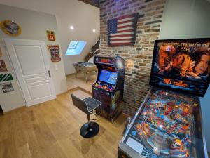 a room with a video game system and an arcade at Gîte des Siècles - Maison du XIVe siècle avec Ascenseur et Cinéma in Saint-Gengoux-le-National