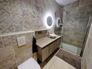 a bathroom with a sink and a shower at Gîte des Siècles - Maison du XIVe siècle avec Ascenseur et Cinéma in Saint-Gengoux-le-National