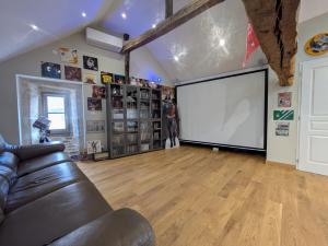 a living room with a couch and a projection screen at Gîte des Siècles - Maison du XIVe siècle avec Ascenseur et Cinéma in Saint-Gengoux-le-National