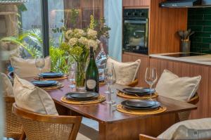 a wooden table with plates and wine glasses at Melasti Dream Residence in Uluwatu