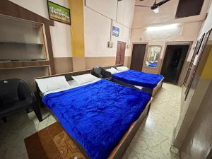 2 Betten in einem Zimmer mit blauer Decke in der Unterkunft The Kaya Pilgrim's Cottage Srirangam in Tiruchchirāppalli