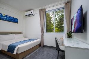 a bedroom with a bed and a desk and a window at Haishu Yuntian 