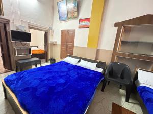 ein Schlafzimmer mit einem Bett mit einer blauen Bettdecke in der Unterkunft The Kaya Pilgrim's Cottage Srirangam in Tiruchchirāppalli