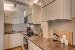 Una cocina con gabinetes blancos y encimera. en Apartment La Roseraie - Alpes Travel - Central Chamonix (sleeps 2-3), en Chamonix-Mont-Blanc 21 fotos más