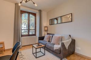 una sala de estar con un sofá y una mesa en Apartment La Roseraie - Alpes Travel - Central Chamonix (sleeps 2-3), en Chamonix-Mont-Blanc